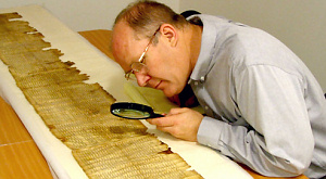 исследователь изучает Свитки Мертвого моря