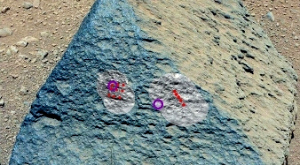 камень «Джейк Матиевич», на котором красным обозначены места попадания лазера ChemCam, а фиолетовым — зоны, обследованные APXS